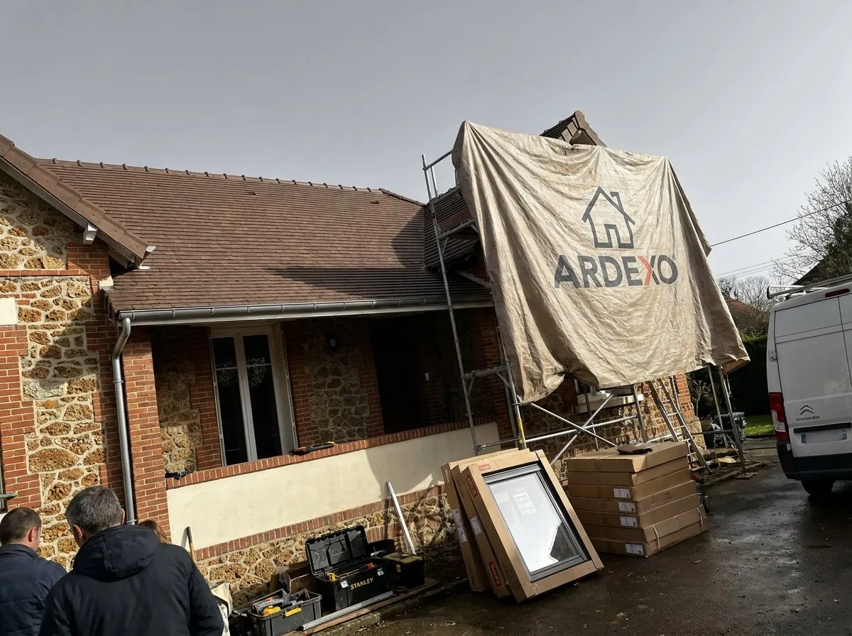 Chantier de couverture Ardexo à Savigny-sur-Orge : bâche Ardexo sur l'échafaudage, fenêtres de toit livrées au pied d'un pavillon en meulière