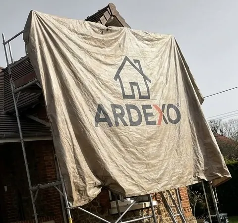 Bâche de protection au logo Ardexo tendue sur un échafaudage de couvreur en Essonne